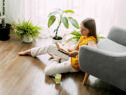 Devojčica čita knjigu na podu / foto: freepik.com