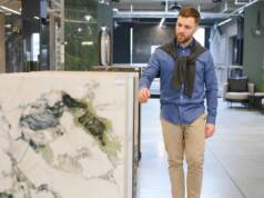 Momak bira pločice velikih formata u salonu / foto: freepik.com