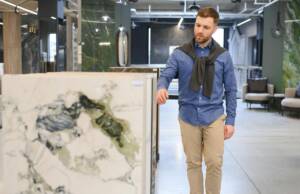 Momak bira pločice velikih formata u salonu / foto: freepik.com