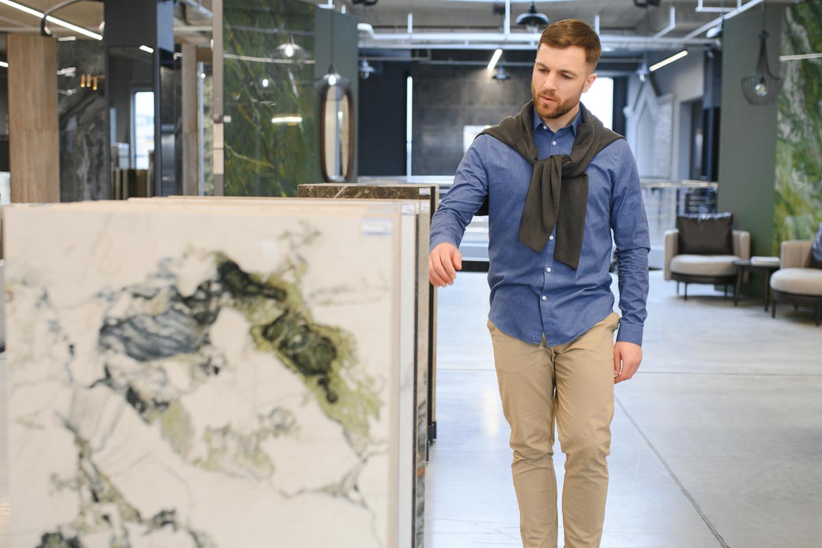 Momak bira pločice velikih formata u salonu / foto: freepik.com